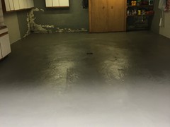 This garage floor needing power washing, crack repair, and resurfacing. The surface was finished with a skim coat of resurfacer.
