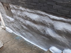 After the repairs were completed, we finished the project by a applying an experior water-proof elastomeric coating to the newly resurfaced foundation and newly build birm so that no area, including the sidewalk seam to the birm, is susceptible to moisture intrusion.