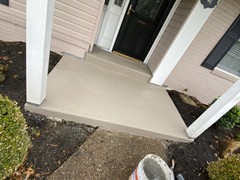 A front porch we power washed, did repairs, and resurfaced with a brown tint color.